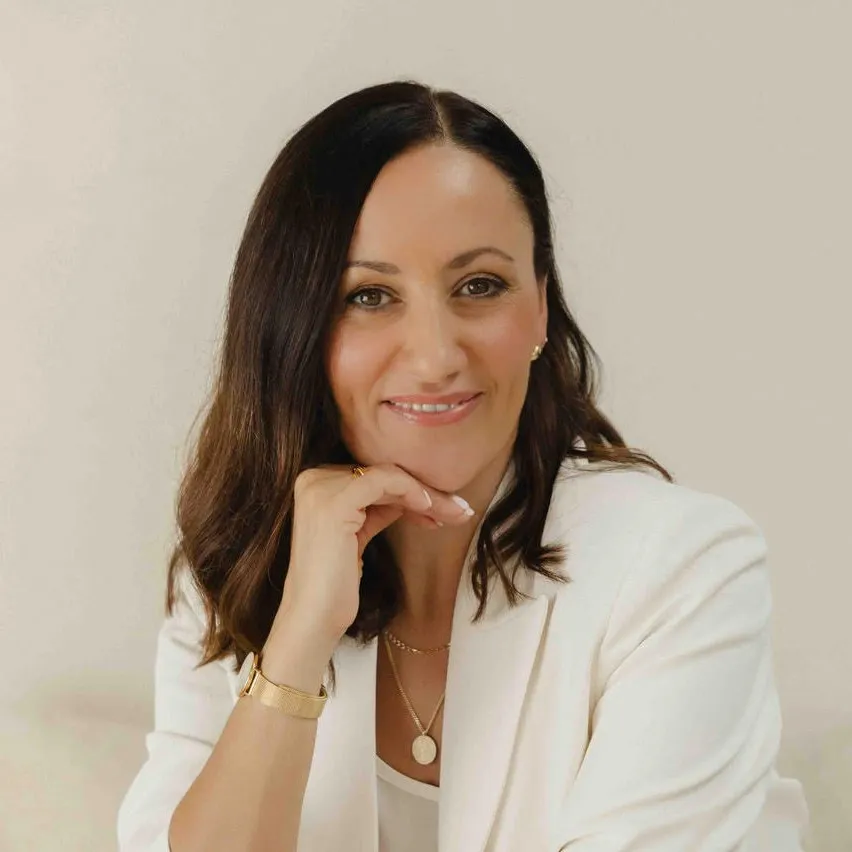 Clare Butler, Squarespace designer, seated in a white suit
