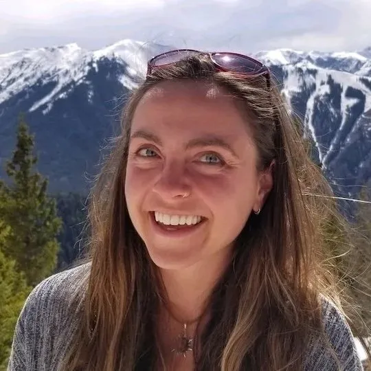 Kessiah Carlbon laughing in front of snow-covered mountains