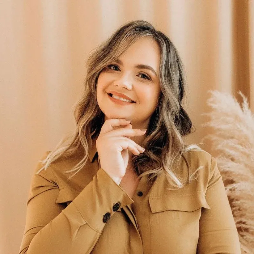 Olga Kolgusheva of Applet Studio, smiling with her hand on her chin