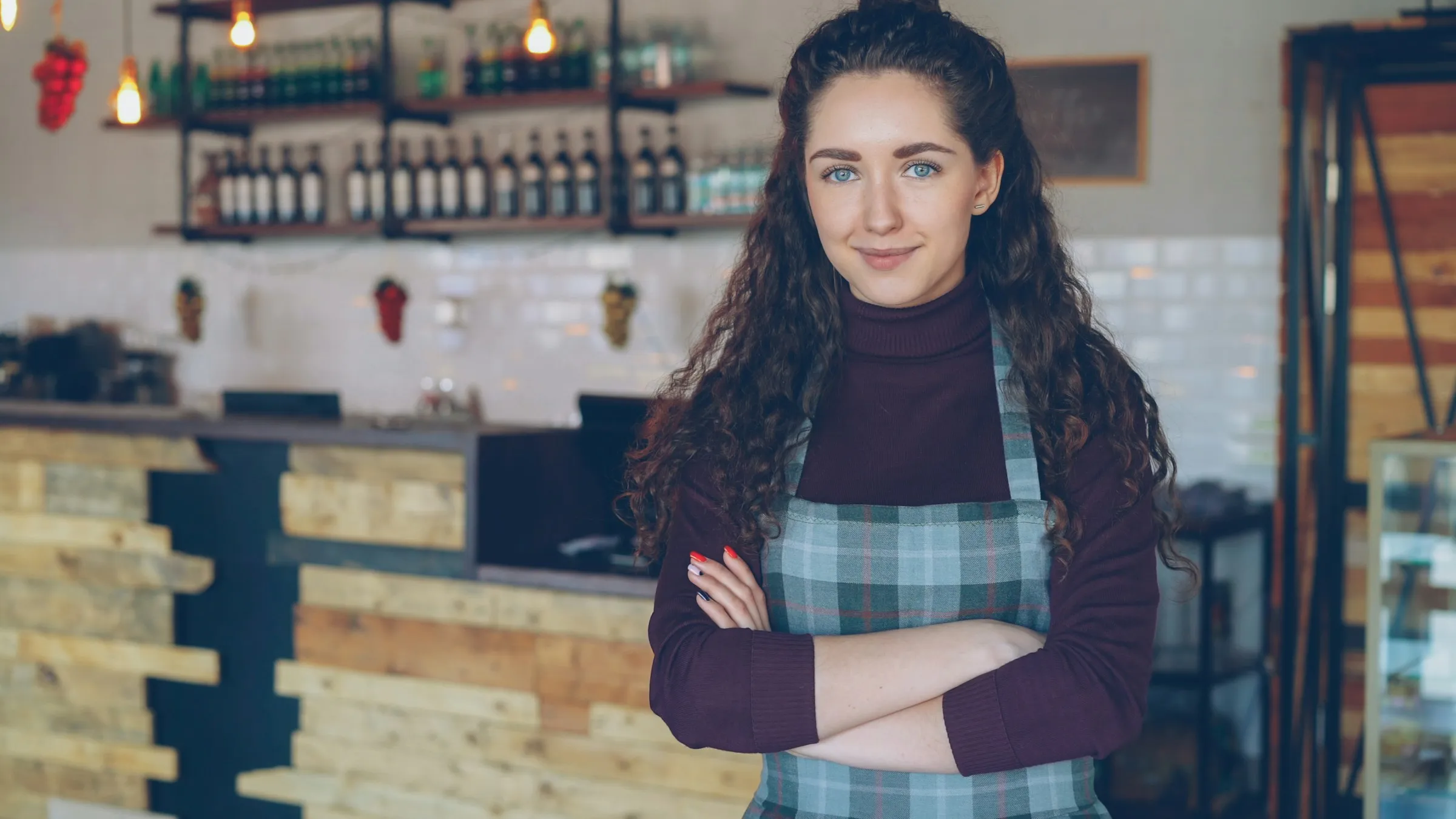 A smiling café owner standing behind her counter