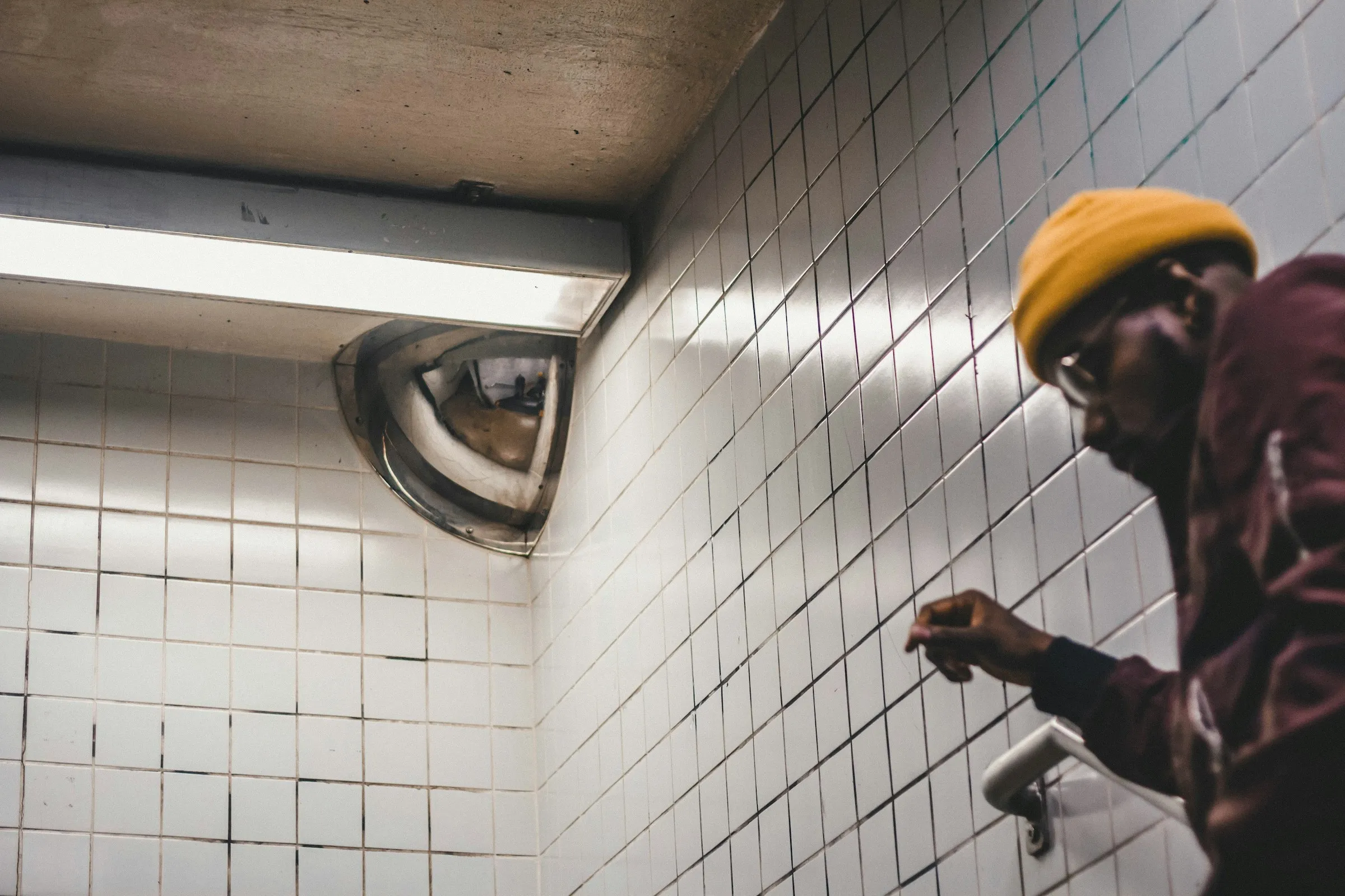 A tradesman in a yellow beanie checking his phone